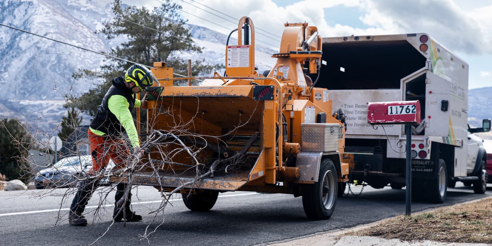 Clean Cuts Trees crew clearing brush into the chipper along an HOA street in Utah