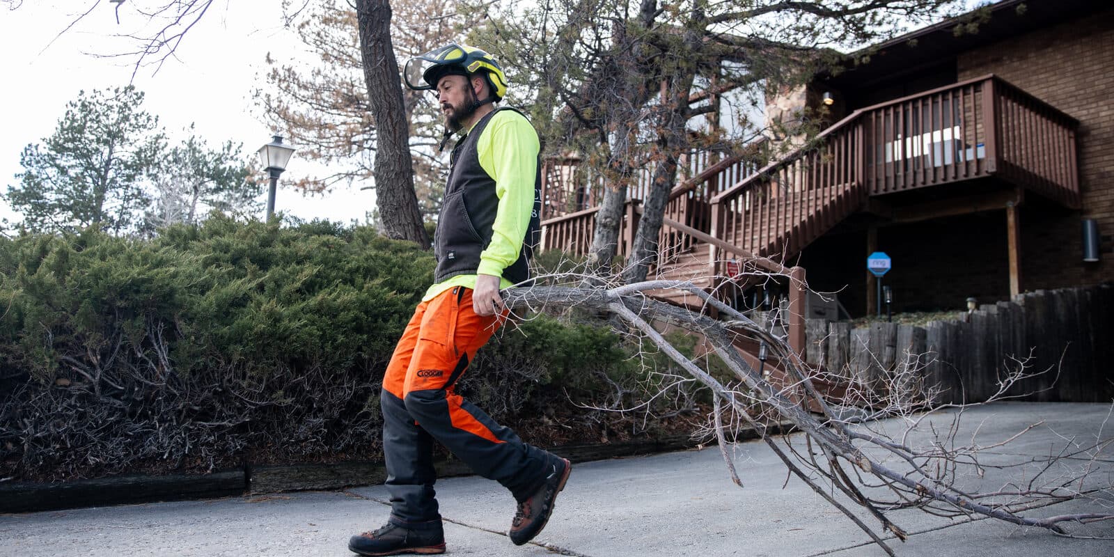 Clean Cuts Trees crew member clearing cut limbs from a managed property in Utah